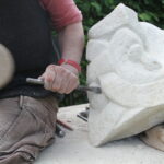 Steinbildhauer bei der Arbeit mit einem Meißel